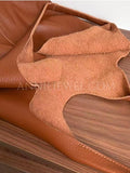 A close-up of a brown leather bag or 