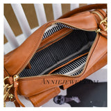 A close-up of a tan leather handbag shown open