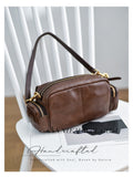 A brown leather crossbody bag with gold-tone hardware