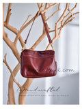 A burgundy leather shoulder bag with gold hardware 