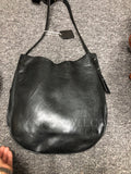 A black leather slouchy shoulder bag with a curved bottom and thin strap