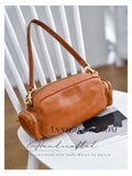 A tan leather shoulder bag with gold-tone hardware.