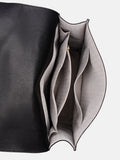 Close-up of a black leather handbag with a gray interior pocket 