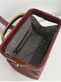 A close-up of a reddish-brown leather handbag showing the interior