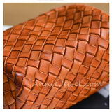 Close-up of a woven leather item in a warm cognac brown