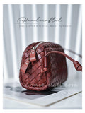 A brown woven leather shoulder bag with a zippered top and strap