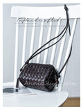 A dark brown woven leather crossbody bag with a long strap,