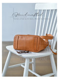 A tan leather crossbody bag with a matching strap