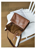 A brown leather shoulder bag with a matching canvas lining