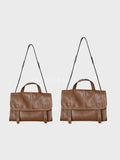 Two brown leather shoulder bags with top handles and thin black shoulder straps