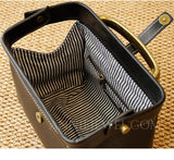 A close-up of a black leather handbag or organizer shown from above